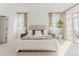 Bright main bedroom features a king bed, neutral décor, and a private balcony at 869 Bluestem Ln, Louisville, CO 80027