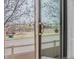 A sunny view of the neighborhood playground with mature trees through a sliding glass door at 869 Bluestem Ln, Louisville, CO 80027