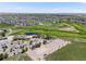 Aerial view of the golf course clubhouse with a parking lot, surrounded by lush greenery and residential area at 16448 E 111Th Pl, Commerce City, CO 80022