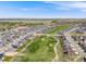 Expansive aerial view of a neighborhood with a golf course winding through it, offering a blend of residential and recreational space at 16448 E 111Th Pl, Commerce City, CO 80022