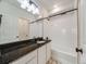 Bathroom with granite countertops, white cabinetry and tiling in the tub and shower area at 16448 E 111Th Pl, Commerce City, CO 80022
