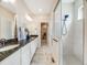 Bathroom features a large granite countertop, white cabinets, shower and tiled floors at 16448 E 111Th Pl, Commerce City, CO 80022