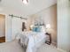 Bright bedroom boasts queen bed, soft hues, and an en-suite bathroom behind a sliding door at 16448 E 111Th Pl, Commerce City, CO 80022