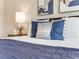 Close up of a well-styled primary bedroom bed featuring blue pillows and a white comforter at 16448 E 111Th Pl, Commerce City, CO 80022