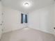 Clean and simple bedroom with plush carpet, minimal decor, and natural light from the window at 16448 E 111Th Pl, Commerce City, CO 80022
