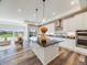 Bright open-concept kitchen featuring a large island, white cabinetry, and a seamless connection to the living area at 16448 E 111Th Pl, Commerce City, CO 80022