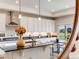 Bright kitchen featuring white cabinets, a dark countertop island, and an adjacent breakfast nook with patio access at 16448 E 111Th Pl, Commerce City, CO 80022