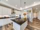 Spacious kitchen with stainless steel appliances, island with dark countertop, and white cabinets at 16448 E 111Th Pl, Commerce City, CO 80022