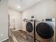 Laundry room boasts modern appliances, stylish wood floors and a neutral color palette at 16448 E 111Th Pl, Commerce City, CO 80022