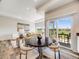 Open-concept living room with a dark wood table and chairs, a patio door, and backyard views at 16448 E 111Th Pl, Commerce City, CO 80022