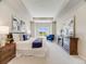 Bright primary bedroom with tray ceilings, an accent chair, and en suite bathroom access at 16448 E 111Th Pl, Commerce City, CO 80022