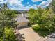 Aerial view of a home with a large driveway and lush landscaping on a sunny day at 1245 Ceres Dr, Lafayette, CO 80026