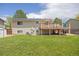 Spacious backyard with lush green lawn, wooden deck, mature trees, and solar panels at 1245 Ceres Dr, Lafayette, CO 80026