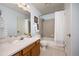 Clean bathroom with a tub and shower combo, light blue walls, and a wood vanity at 1245 Ceres Dr, Lafayette, CO 80026
