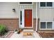 Inviting front door with brick accents, a decorative welcome mat, and potted plants at 1245 Ceres Dr, Lafayette, CO 80026