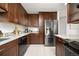 Modern kitchen showcases stainless steel appliances, granite countertops, dark cabinetry, and tile flooring at 1245 Ceres Dr, Lafayette, CO 80026