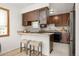 Kitchen featuring modern appliances, wood cabinets, and a breakfast bar with stools at 1245 Ceres Dr, Lafayette, CO 80026