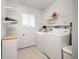 Bright laundry room featuring a washer, dryer, and ample shelving for organized storage at 1245 Ceres Dr, Lafayette, CO 80026