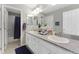 Bright bathroom featuring dual sinks, granite countertop, and a shower with a stylish blue curtain at 6577 S Kewaunee Way, Aurora, CO 80016