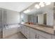 Well-lit bathroom with double sinks, tub, and walk-in shower at 6577 S Kewaunee Way, Aurora, CO 80016