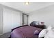 Bedroom featuring a bed with a purple comforter, closet, dresser, and access to another room at 6577 S Kewaunee Way, Aurora, CO 80016