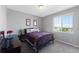 Bedroom with natural light from window, bed with decorative pillows, and a sleek dark wood dresser at 6577 S Kewaunee Way, Aurora, CO 80016