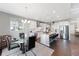 Open-concept kitchen with stainless steel appliances, modern lighting, and granite countertops, connected to the dining area at 6577 S Kewaunee Way, Aurora, CO 80016