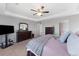 A main bedroom featuring a ceiling fan, dresser, and a mirror at 6577 S Kewaunee Way, Aurora, CO 80016