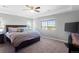 Spacious main bedroom with tray ceiling and large window view at 6577 S Kewaunee Way, Aurora, CO 80016