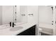 Modern bathroom featuring a sleek vanity with black fixtures and a subway-tiled shower-tub combo at 5831 Galena St, Denver, CO 80238