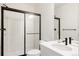 Modern bathroom featuring a sleek glass shower with black hardware and a white vanity with dark fixtures at 5831 Galena St, Denver, CO 80238