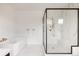 Stylish main bathroom with a soaking tub and a modern walk-in shower with marble and black accents at 5831 Galena St, Denver, CO 80238