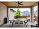 Covered outdoor dining area with a modern table, six chairs, and a view of the backyard at 5831 Galena St, Denver, CO 80238