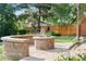 Backyard with a fire pit and seating surrounded by a well-maintained yard and fence at 5115 Bristol St, Arvada, CO 80002