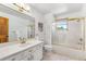 Bright bathroom featuring a large mirror, white cabinets, and shower-over-tub at 5115 Bristol St, Arvada, CO 80002