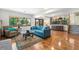 Bright living room with hardwood floors, plush blue seating, and large windows at 5115 Bristol St, Arvada, CO 80002