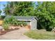 Charming backyard shed surrounded by lush landscaping and a stone pathway, offering storage and garden potential at 5115 Bristol St, Arvada, CO 80002