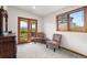 Bright sitting room with chairs, a side table, and a window and door leading to the balcony at 5115 Bristol St, Arvada, CO 80002