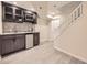 Basement bar area with stainless steel refrigerator, wine rack, gray backsplash, and wood-look floors at 10672 Wintersweet Pl, Parker, CO 80134