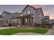 Charming home boasts a covered porch with stone pillars and lush green lawn at 11261 Moonshimmer St, Littleton, CO 80125