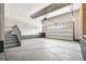 Large garage with concrete floor and stairs, featuring an insulated garage door and opener at 11261 Moonshimmer St, Littleton, CO 80125