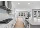 Bright kitchen with stainless steel appliances, white cabinets, and a large island with waterfall countertops at 11261 Moonshimmer St, Littleton, CO 80125