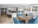 Open-concept kitchen, dining area with hardwood floors, white cabinets, and a large island at 11261 Moonshimmer St, Littleton, CO 80125
