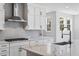 Bright kitchen with stainless steel appliances, white cabinets, and a large island with marble countertops at 11261 Moonshimmer St, Littleton, CO 80125