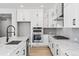 This kitchen features stainless steel appliances, white cabinets, and quartz countertops at 11261 Moonshimmer St, Littleton, CO 80125