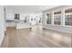 Bright, open-concept living area with hardwood floors, and a modern kitchen in the background at 11261 Moonshimmer St, Littleton, CO 80125