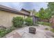 Landscaped backyard with a stone patio, fire pit, privacy fence, and lush greenery at 671 Brentwood St, Lakewood, CO 80214