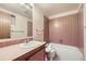 Cozy bathroom featuring classic tile, a bathtub-shower combo, and a well-lit vanity area at 671 Brentwood St, Lakewood, CO 80214