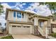 Beautiful two-story home with a covered front porch, stone accents, attached garage, and lush landscaping at 10626 Cherrybrook Cir, Highlands Ranch, CO 80126
