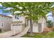 Inviting two-story home with a covered front porch, stone accents, attached garage, and mature tree in the yard at 10626 Cherrybrook Cir, Highlands Ranch, CO 80126